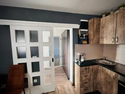 a kitchen with a door leading into a kitchen with a sink at Svetli dom in Sutomore
