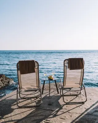 two chairs and a table on the beach at La Mer Beach Residence in Ulcinj