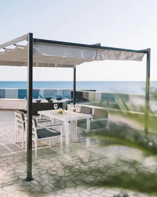 a white table and chairs on a balcony with the ocean at La Mer Beach Residence in Ulcinj