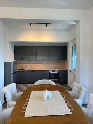 a living room with a table and a kitchen at La Mer Beach Residence in Ulcinj