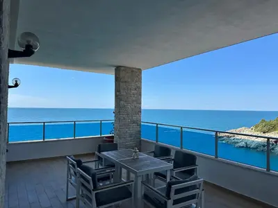 a balcony with a table and chairs and the ocean at La Mer Beach Residence in Ulcinj