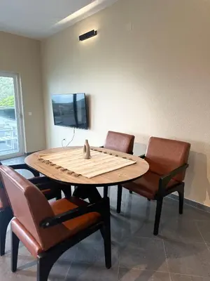 a wooden table with chairs and a tv on a wall at La Mer Beach Residence in Ulcinj
