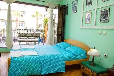 a bedroom with a bed with blue sheets and a window at Studio Mimi City Center Bar in Bar