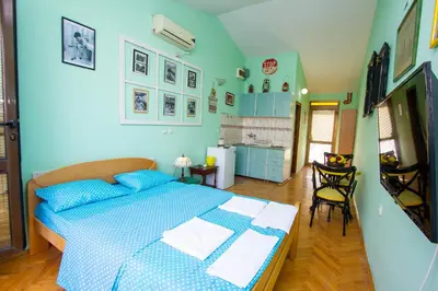 a blue bedroom with a bed and a kitchen at Studio Mimi City Center Bar in Bar