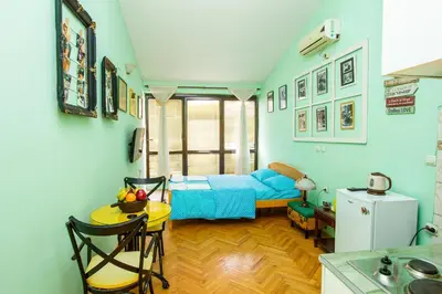 a bedroom with a blue bed and a table and chairs at Studio Mimi City Center Bar in Bar