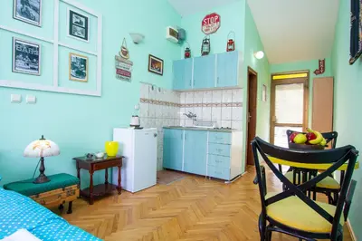 a kitchen with blue cabinets and a white refrigerator at Studio Mimi City Center Bar in Bar