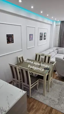 a living room with a table and chairs and a couch at Elena apartmani Podgorica in Podgorica