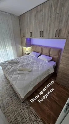 a bedroom with a large bed with a purple light at Elena apartmani Podgorica in Podgorica