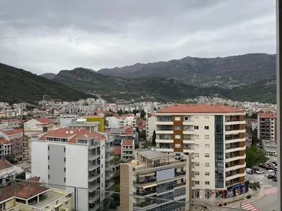 a city with buildings and mountains in the background at Apartment WOW Budva - With free parking in Budva