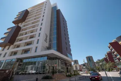 a tall building on a street in a city at Apartment WOW Budva - With free parking in Budva