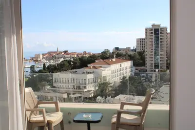 a balcony with two chairs and a view of a city at WoW APARTMENT'S 604-607 in Budva