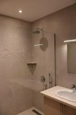 a shower with a glass door next to a sink at WoW APARTMENT'S 604-607 in Budva