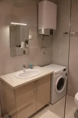 a bathroom with a sink and a washing machine at WoW APARTMENT'S 604-607 in Budva