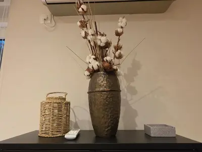 a vase with flowers in it sitting on a table at Peaceful 2bd apartment near Sveti Stefana in Pržno