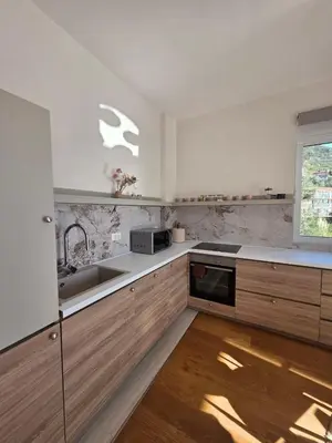 a kitchen with wooden cabinets and a sink and a window at Peaceful 2bd apartment near Sveti Stefana in Pržno