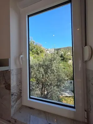 a bathroom window with a view of a tree at Peaceful 2bd apartment near Sveti Stefana in Pržno