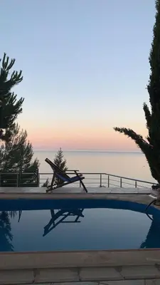 a pool with a chair and the ocean in the background at TALi in Ulcinj