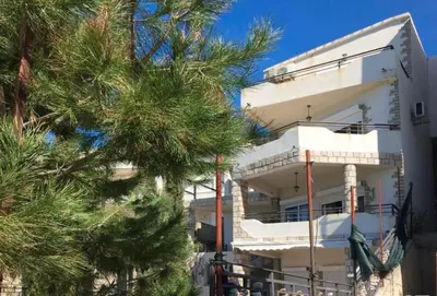 a white building with a tree in front of it at TALi in Ulcinj