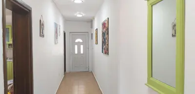 a hallway with a green door and pictures on the walls at TALi in Ulcinj