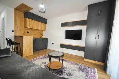 a living room with a table and a tv and a kitchen at Studio Dobra Voda 13 in Dobra Voda