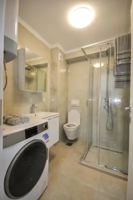 a bathroom with a toilet and a washing machine at Studio Dobra Voda 13 in Dobra Voda