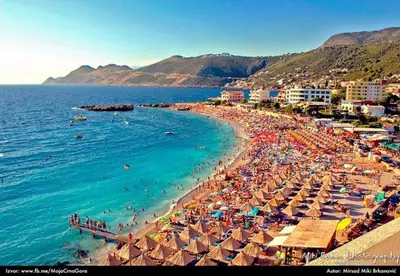 a beach with umbrellas and people in the water at Studio Dobra Voda 13 in Dobra Voda