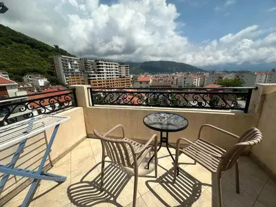 a balcony with chairs and a table and a view at Apartments Manojlovic in Budva