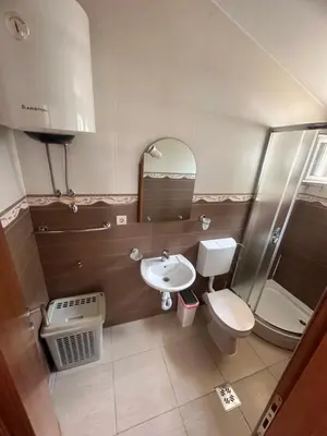 a bathroom with a sink and a toilet and a mirror at Apartments Manojlovic in Budva