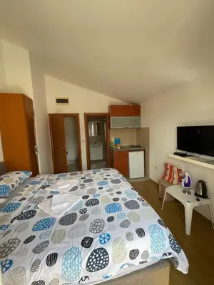 a bedroom with a bed with a blue and white comforter at Apartments Manojlovic in Budva
