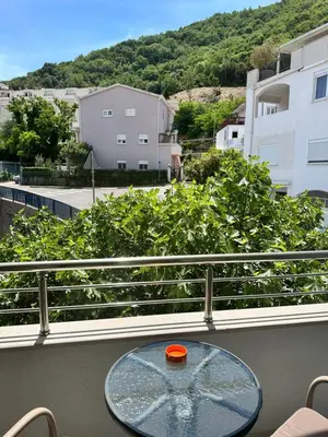 a glass table on a balcony with a view of a city at Apartments Manojlovic in Budva