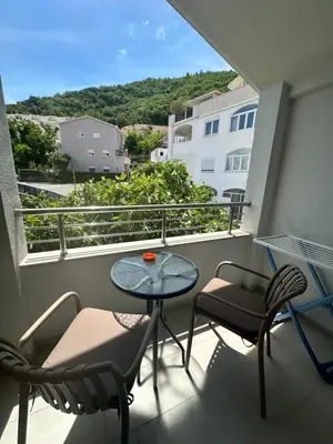 a balcony with a table and chairs and a view at Apartments Manojlovic in Budva