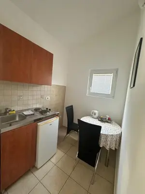 a small kitchen with a table and a sink at Apartments Manojlovic in Budva