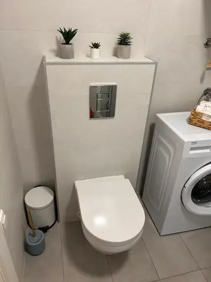 a bathroom with a toilet and a washing machine at Sea La Vie in Bar