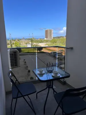 a table and chairs on a balcony with a view of a parking lot at Sea La Vie in Bar