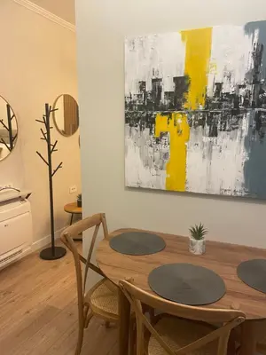 a dining room table with chairs and a painting on the wall at Sunrise Suite in Kotor