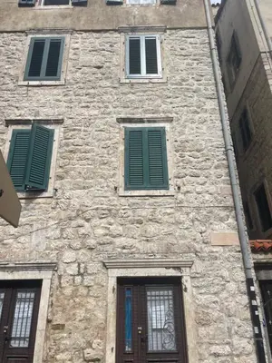a stone building with green shutters on it at Sunrise Suite in Kotor