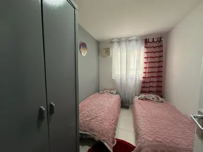 a small room with two beds and a window at Apartman Nenezic in Budva