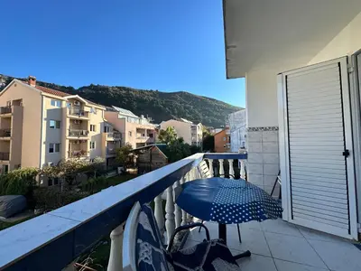 a balcony with an umbrella and a bike on a balcony at Apartman Nenezic in Budva