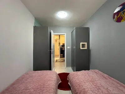 a small bedroom with two beds and a hallway at Apartman Nenezic in Budva