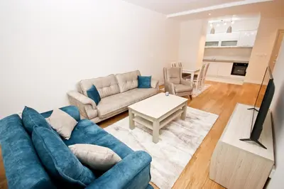 a living room with a blue couch and a table at Sara in Bar