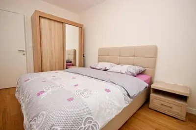 a bedroom with a bed with a pink and white comforter at Sara in Bar