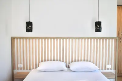 a bed with two pillows and two lights above it at Tiny House with Hot Tub & View in Ulcinj