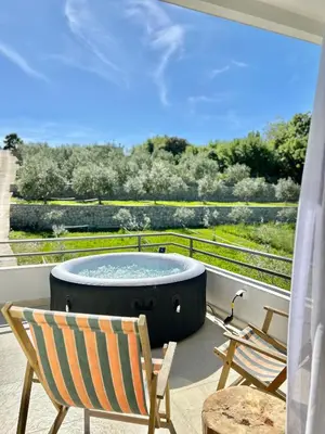 a hot tub on a balcony with two chairs and a table at Tiny House with Hot Tub & View in Ulcinj