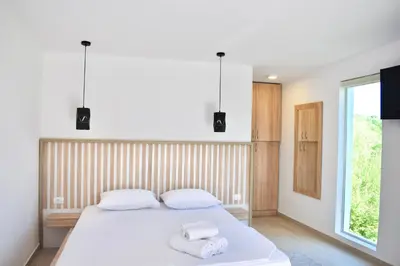 a bedroom with a white bed with towels on it at Tiny House with Hot Tub & View in Ulcinj