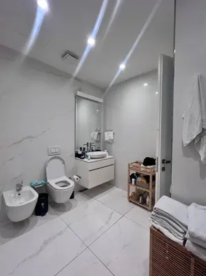 a white bathroom with a toilet and a sink at Duklejski pogled in Budva