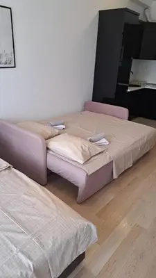 two beds sitting in a room with ainylinylinylinyl at Studio apartment in Bar