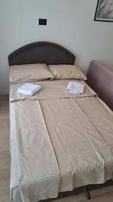 a large bed with two pillows on top of it at Studio apartment in Bar