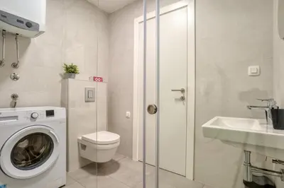 a bathroom with a washing machine and a sink at Studio apartment in Bar