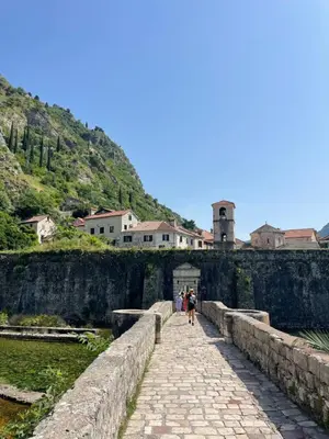 a group of people walking over a stone bridge at Spirit of Kotor in Kotor