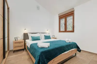 a bedroom with a large bed and a window at Apartmani Nadja in Škaljari